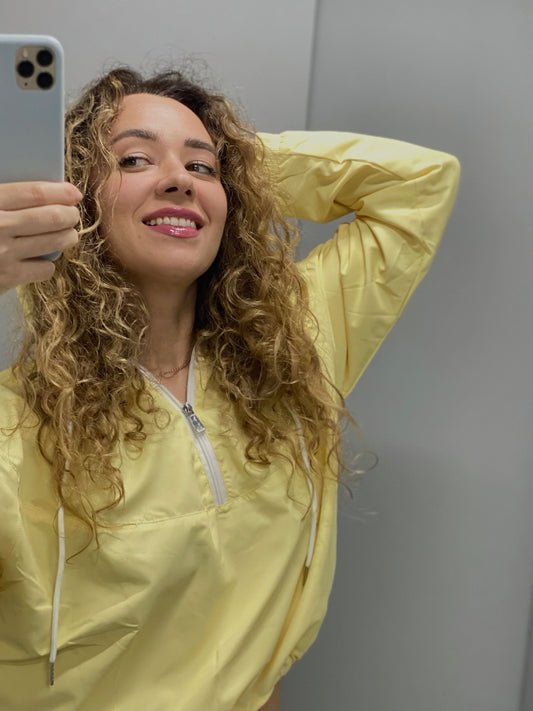 Female model in lightweight yellow windbreaker, styled for casual fall fashion and rainy day comfort