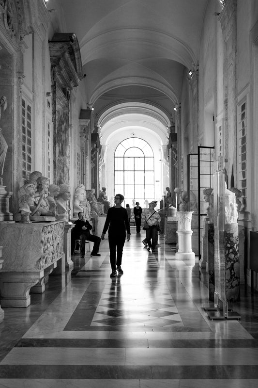 Black-and-white photo of people in a museum observing sculptures that express different emotions, reflecting curiosity, awe, and contemplation