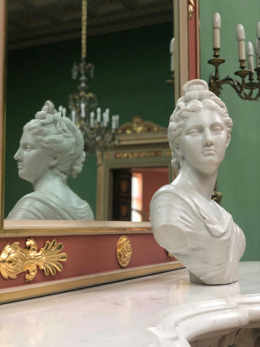 Sculpture of a woman’s head reflected in a mirror, symbolizing self-awareness and living in the present moment