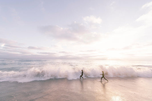Ocean wave with two people running — blog post on flow and gentle presence