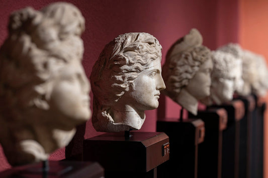 Row of statues with heads in a line, symbolizing how emotional conditioning and learned patterns shape our thoughts and reactions over time.