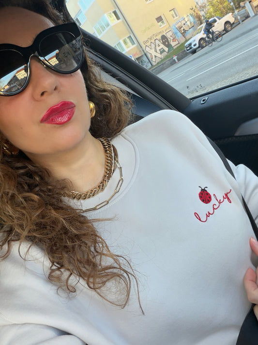 Woman wearing Lucky ladybug embroidered relaxed fit sweatshirt styled for cozy everyday look