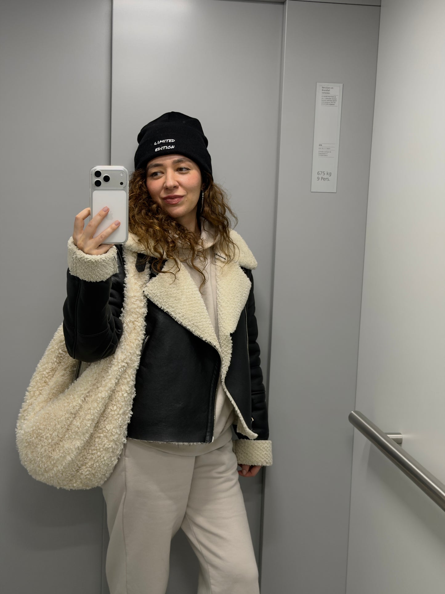 Woman wearing a black embroidered limited edition beanie, minimalist everyday style