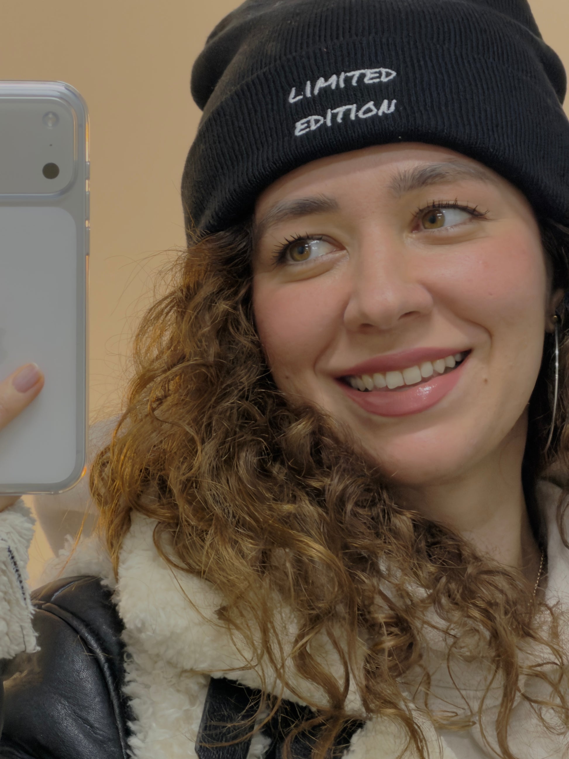 Woman wearing a black embroidered limited edition beanie, minimalist everyday style