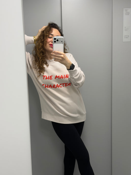Woman wearing a unisex relaxed crew neck sweatshirt with “the main character” print