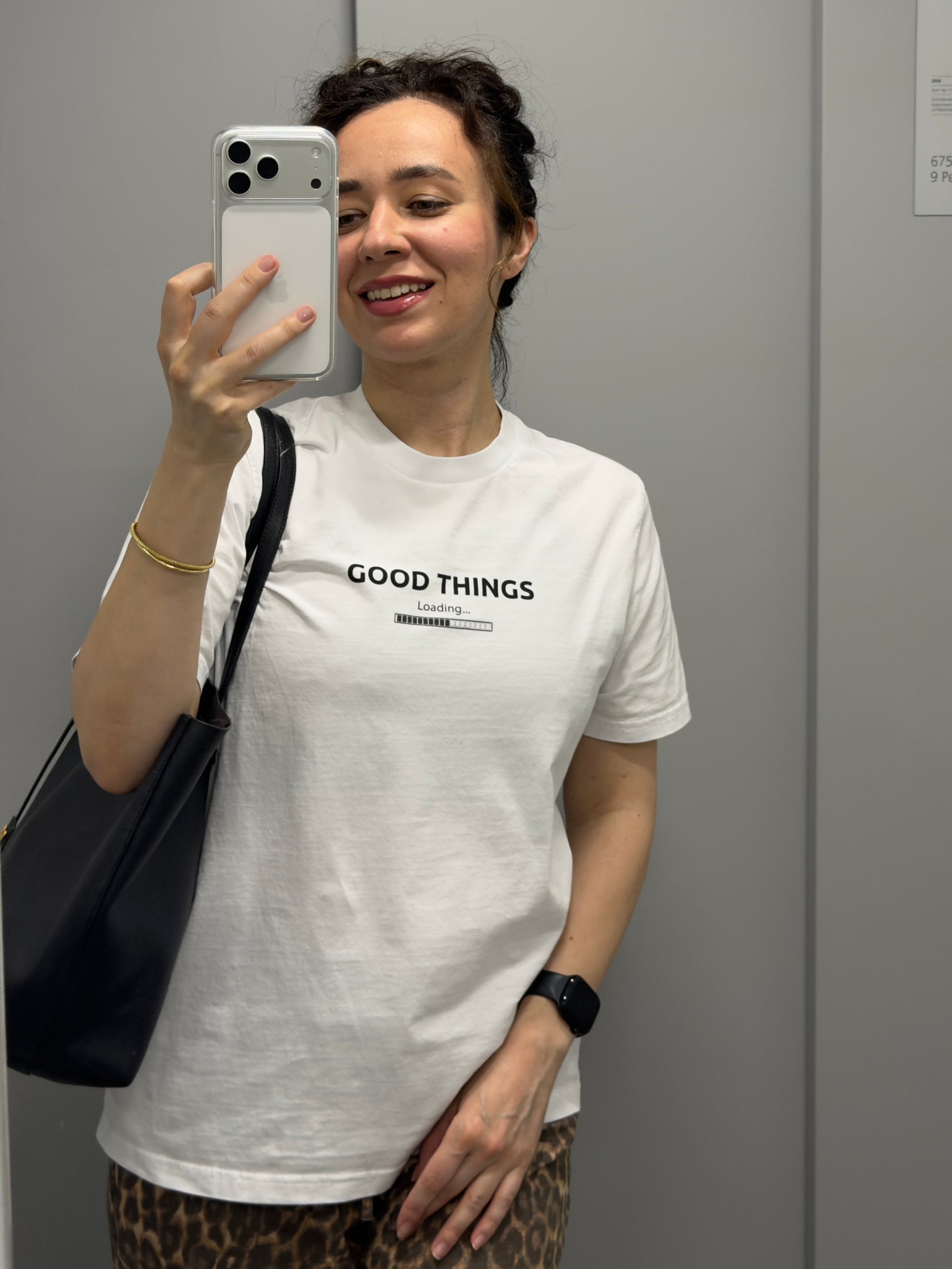 Woman wearing a white organic cotton graphic tee with "Good Things Loading" print, minimal and relaxed style — Island of Calm