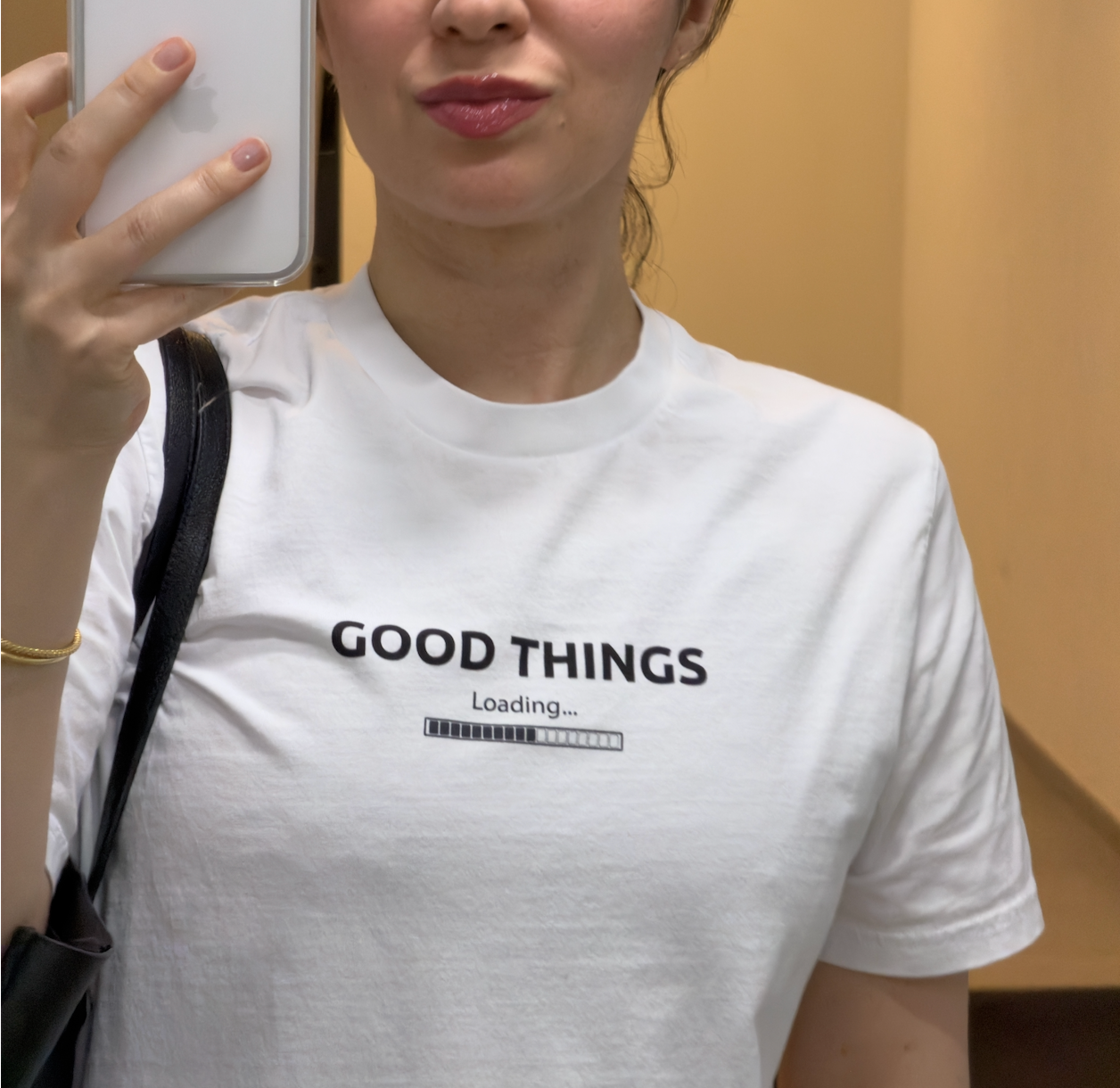 Woman wearing a white organic cotton graphic tee with "Good Things Loading" print, minimal and relaxed style — Island of Calm