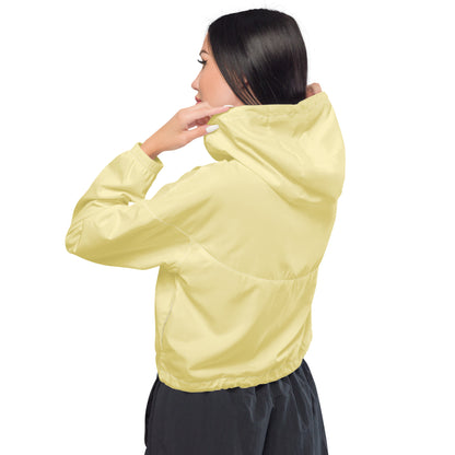 Woman seen from the back wearing a soft yellow cropped windbreaker, showcasing its lightweight and water-resistant desig