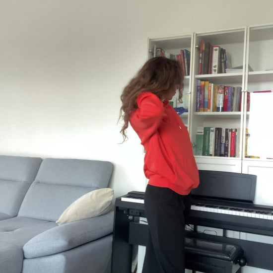 Video with a woman in a soft orange unisex hoodie with “joy keeper” embroidery on the sleeve, made from organic cotton — eco-friendly minimalist sweatshirt.