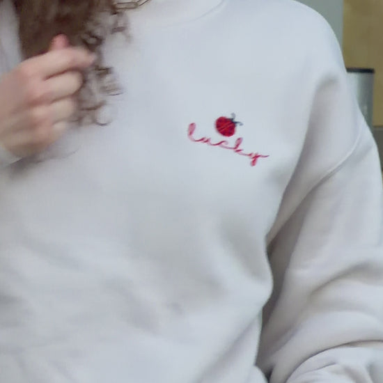 Video of woman wearing Lucky ladybug embroidered sweatshirt in relaxed everyday styling