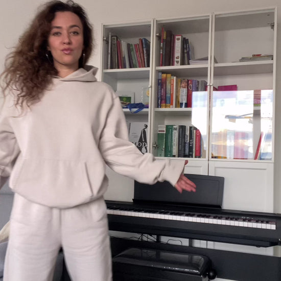 Model wearing oversized hoodie in Dust, styled with matching sweatpants for cozy loungewear look.