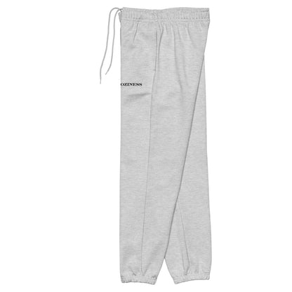 Side view of heavyweight sweatpants in Athletic Heather with black “coziness” embroidery, elastic cuffs, and relaxed street-style fit.