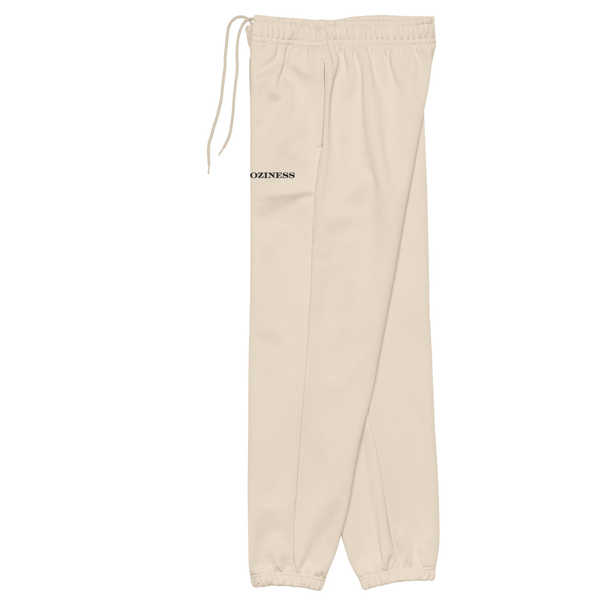 Side view of heavyweight sweatpants in Dust with brushed fleece, black “coziness” embroidery, deep side pockets, and relaxed unisex fit.